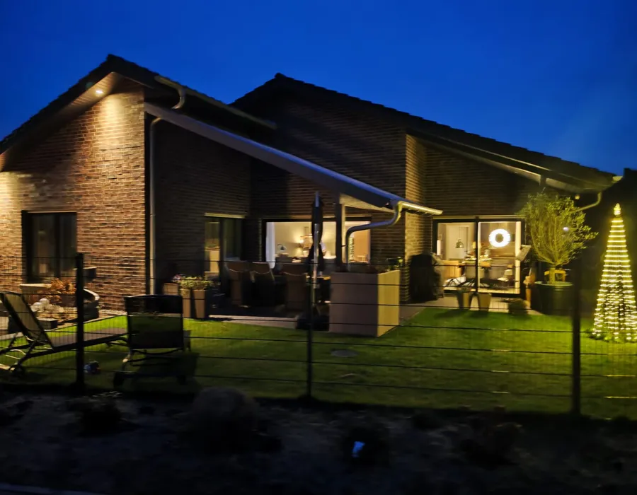 Bungalow mit Satteldach in Varloh in der blauen Stunde mit beleuchteter Terrasse