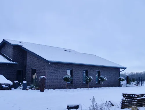 Bungalow mit Satteldach in Varloh im Winter mit Schnee auf dem Dach