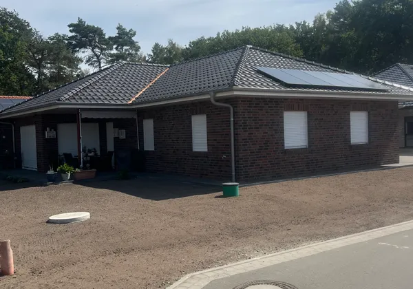 Winkelbungalow mit Walmdach in Varloh, Hausecke mit Photovoltaikanlage